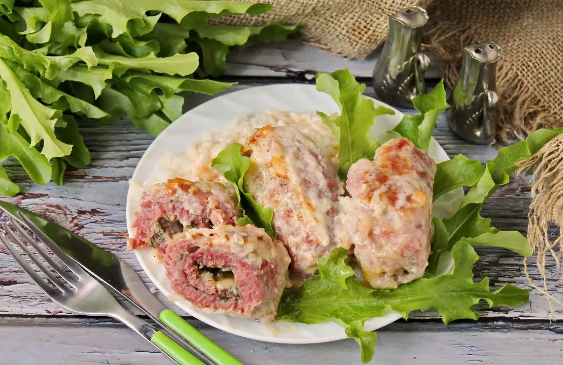 Meat rolls with cheese and herbs in sour cream and garlic sauce