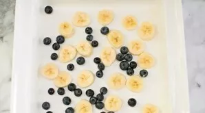 Smear the shape of the cake about 22/22 cm in size with butter. Put half of the sliced bananas and blueberries on the bottom.