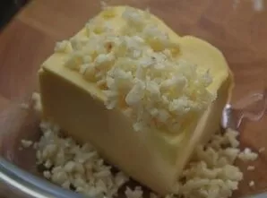 Cut the bread in half lengthwise. Finely chop the garlic cloves. Put the butter and chopped garlic in a bowl. Melt in the microwave for a...