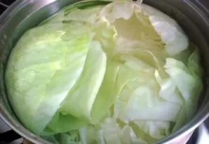 Cut off the stalk from the head of cabbage and separate it into separate leaves. Cut the central stem from each leaf. Put all the leaves ...