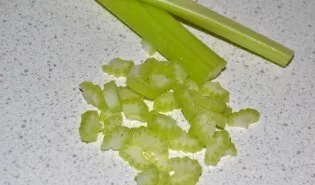 Wash and cut the celery lengthwise, then chop finely.