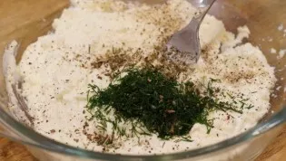First of all, start with the filling. Mash the feta with chopped garlic, sour cream, pepper, dill and basil.