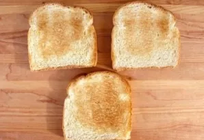 Take three slices of wheat bread and toast them in a toaster or pan until they become crispy.