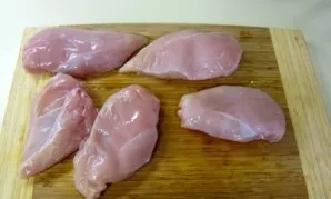 Wash the chicken fillet, dry it, cut into thin slices. Carefully knock out each piece.