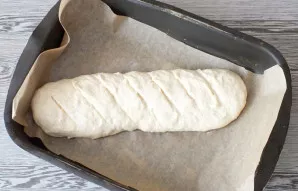 Line the baking dish with baking paper. Carefully move the workpiece. Make diagonal cuts on the surface with a wet knife. Bake in the ove...