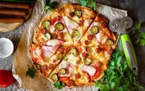 Cut the finished pizza into portions and serve immediately.