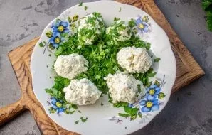 Finely chop the fresh parsley, form balls from the cheese mass and roll in greens.