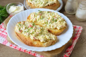 Grease the sandwiches with crab filling, sprinkle with finely chopped herbs for decoration.