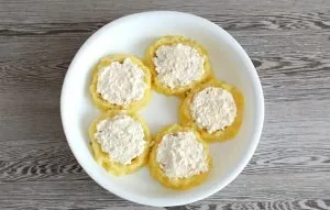 Apply sour cream and cheese on top. Smooth it out. Place the tin with cheesecakes in an oven preheated to 200 degrees for 15 minutes.