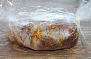 Pour white wine into the sleeve and tie the other side. We put it in a baking dish with a little water in the bottom.