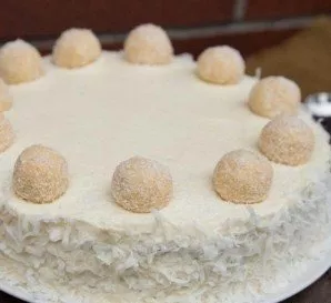 Decorate the cake with coconut shavings and Raffaello candies.