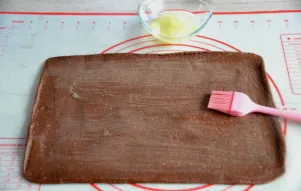 Roll out the cocoa dough into a rectangular layer the same size as the dough. Brush the dough with an egg beater and place the previously...
