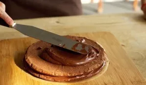 Carefully place the second layer of cake on top and coat all sides of the cake with frosting.