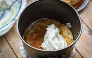 Start collecting the cake. Put baking paper on the bottom of the mold, put a pancake on top, then lay out 2-3 tablespoons of cream and di...
