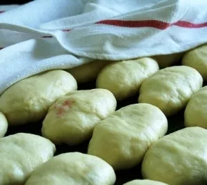 Place the buns on a lightly buttered baking sheet.