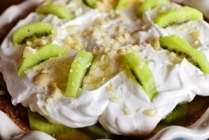 If desired, you can sprinkle a handful of nuts on top. Thats all, the cake with kiwi and whipped cream is ready.