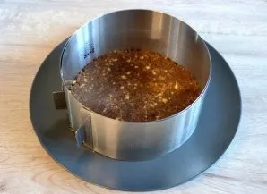 To collect the cake, take a pastry ring, lay out 1/3 of the chocolate-biscuit mass, squeeze the base of the cake.