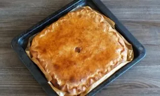 Remove the finished cake from the oven. Grease the top with a piece of butter, cover with a towel and leave for 30 minutes.