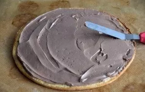 When the scones have cooled completely, start assembling the cake, spread the bottom layer with chocolate cream.