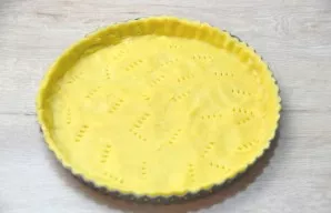 Transfer the dough to a baking dish, form low edges, about 2-3 cm, beat the bottom with a fork.