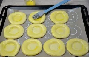 Lubricate the dough blank with the prepared mixture of milk and egg yolk. With the help of the convex side of the spoon, you can expand a...