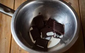 Put the bowl on a saucepan with water, add crushed chocolate to it and pour the cream.