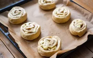 Cover the baking sheet with baking paper and place the buns at a great distance from each other. Brush the surface of each piece with a b...