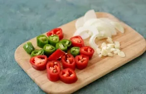 Cut the chilli and garlic into slices, the onion into half rings.
