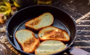 Heat the pan well, lightly coat with butter. Put the slices of baguette in a pan, fry on both sides until golden brown.