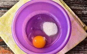 Break an egg into a bowl, add salt and sugar.