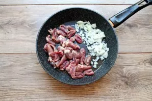 Pour vegetable oil into the pan, add finely chopped onions. Cut off the heart films and excess fat, cut in half and put in a pan with oni...