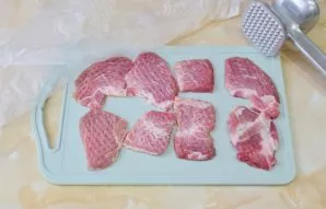 Cut the meat into small pieces and knock it out, covering with a film.