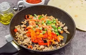Heat a little vegetable oil in a pan, add the mince and fry, breaking with a spatula, for 5 minutes. Then put the vegetable mixture in th...