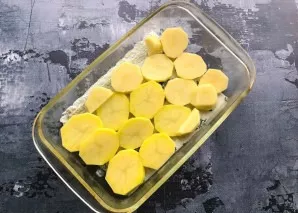 Grease the heat-resistant form with vegetable oil, put sliced potatoes on the bottom and salt.