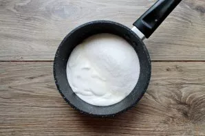 Pour sour cream into a saucepan or stewpan with a thick bottom and add sugar, mix.