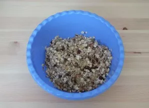 In a bowl, crush the banana, add oatmeal, chopped walnuts, cycum, grain mixture, raisins. Stir.