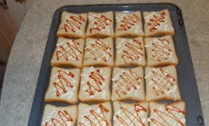 Place the bread on a baking sheet and spread mayonnaise and ketchup on each slice.