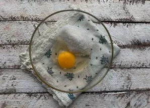 Break an egg into a deep saucer, add sugar, beat until foam forms.