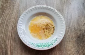 Add an egg to the container, add salt and mix with a fork, add pepper and mix again.