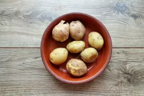 Rinse the potatoes well with a soft brush and boil in salted water until almost tender, dry.