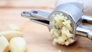 Squeeze the garlic with a garlic press.