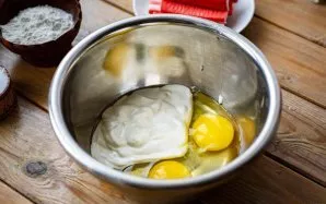 Prepare the dough. Break eggs into a bowl, add sour cream and salt. Beat these ingredients until a homogeneous mass is formed.