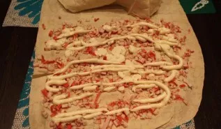 I cut the crab sticks into small pieces and put them on top of the lavash, then pour them with mayonnaise.