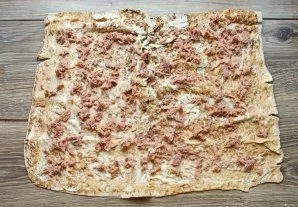 Shred the tuna with a knife or fork. Spread the lavash with mayonnaise and spread the tuna in an even layer.