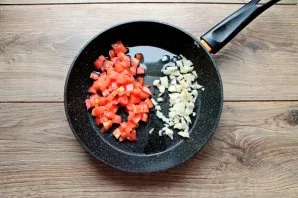 Heat the pan with oil over medium heat. Peel the onion and chop it finely, cut the tomatoes into cubes. Put vegetables in a pan.