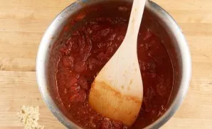 Finely chop the garlic. Fry half for 1 minute in a saucepan in heated oil. Then pour the wine. Cook for another 1 minute. Then pour the t...