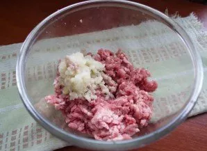 Grind onions in a meat grinder or chop with a food processor. Add to minced meat.