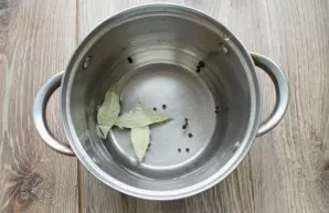Pour clean water into a saucepan, add bay leaf and pepper. Bring the water to a boil.