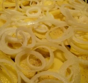 Peel the onion, cut it into thin rings and place it evenly on the potatoes. Salt and pepper.