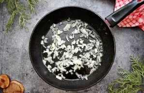 Pour vegetable oil into the pan, add finely chopped onions and fry for 2 minutes.